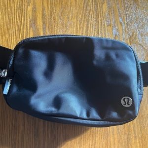 Black Lululemon belt bag with white lettering